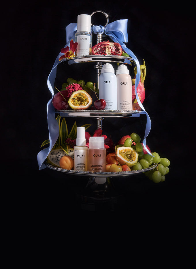 Three-tiered tray with skincare products and fruits on a black background