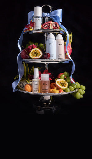 Three-tiered tray with skincare products and fruits on a black background